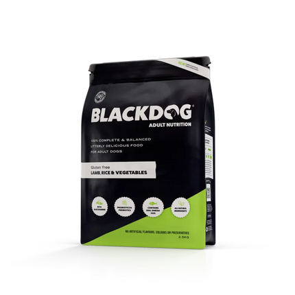 Black dog eating Macaw and Friends adult lamb rice and vegetables dog food in a bowl.